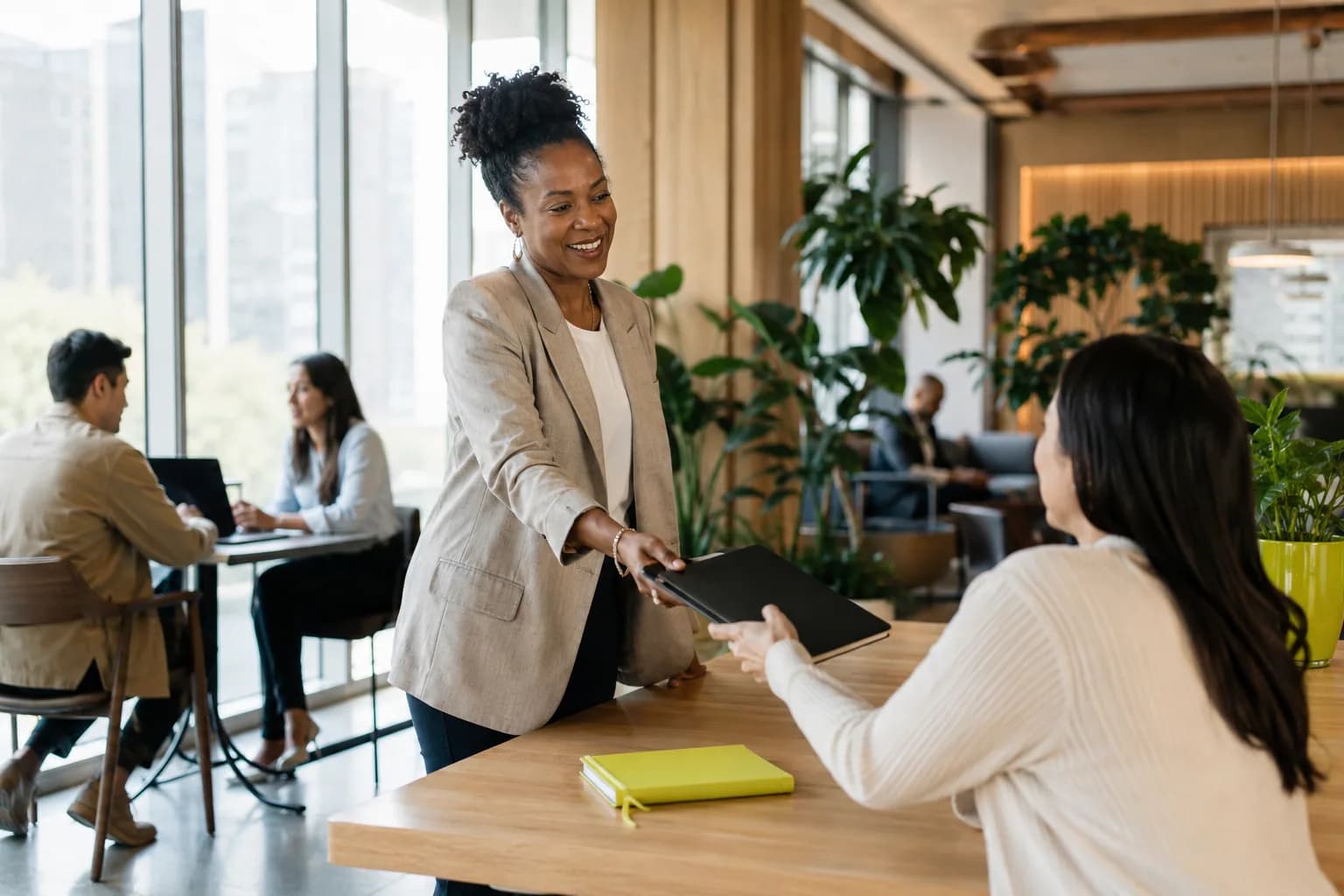 A confident founder sharing a polished media kit with a colleague in a sunlit modern office, illustrating a founder whose authority assets are in place before going public.