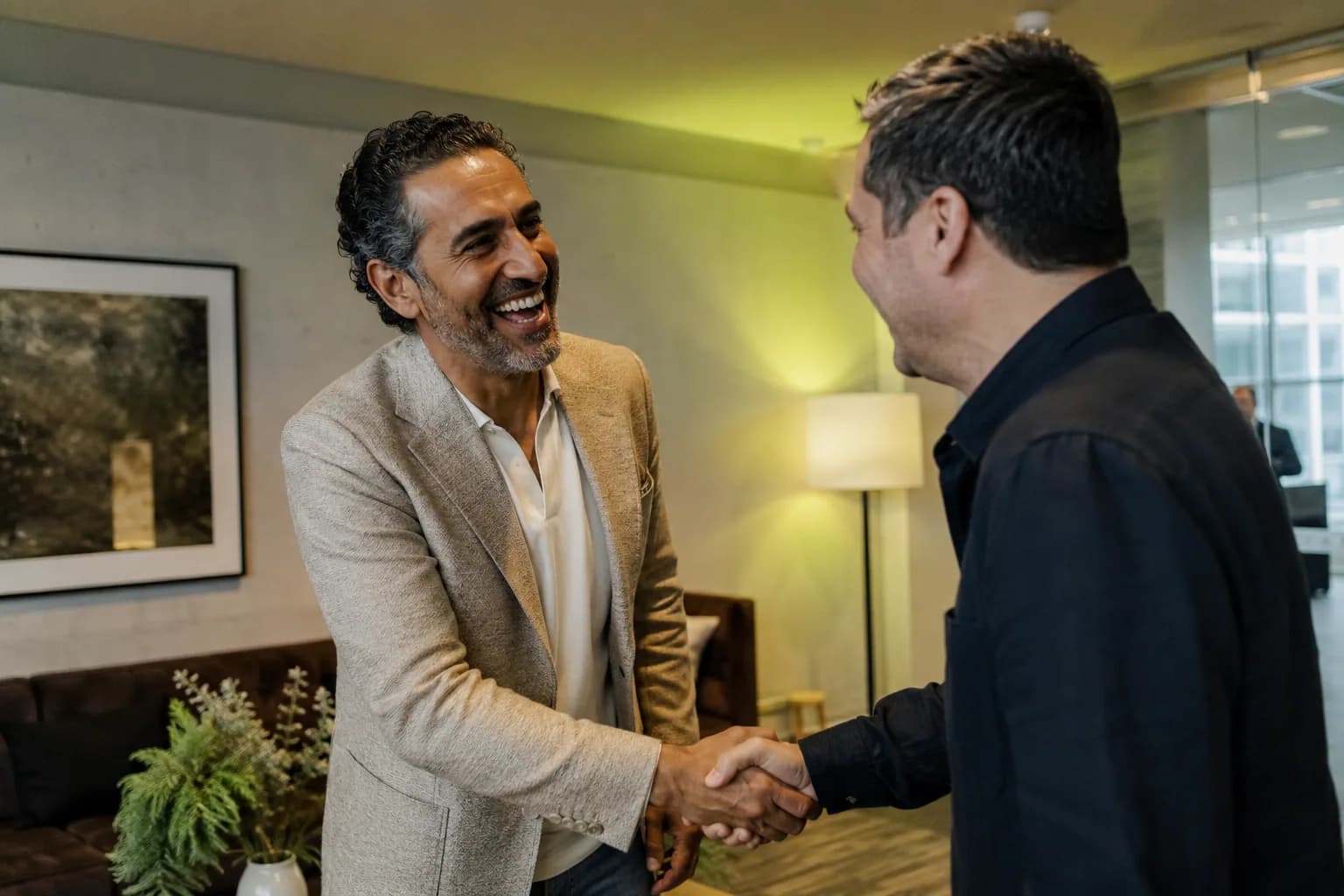 A founder warmly greeted by a host backstage before a talk, showing how strong authority assets make a founder easy to book.