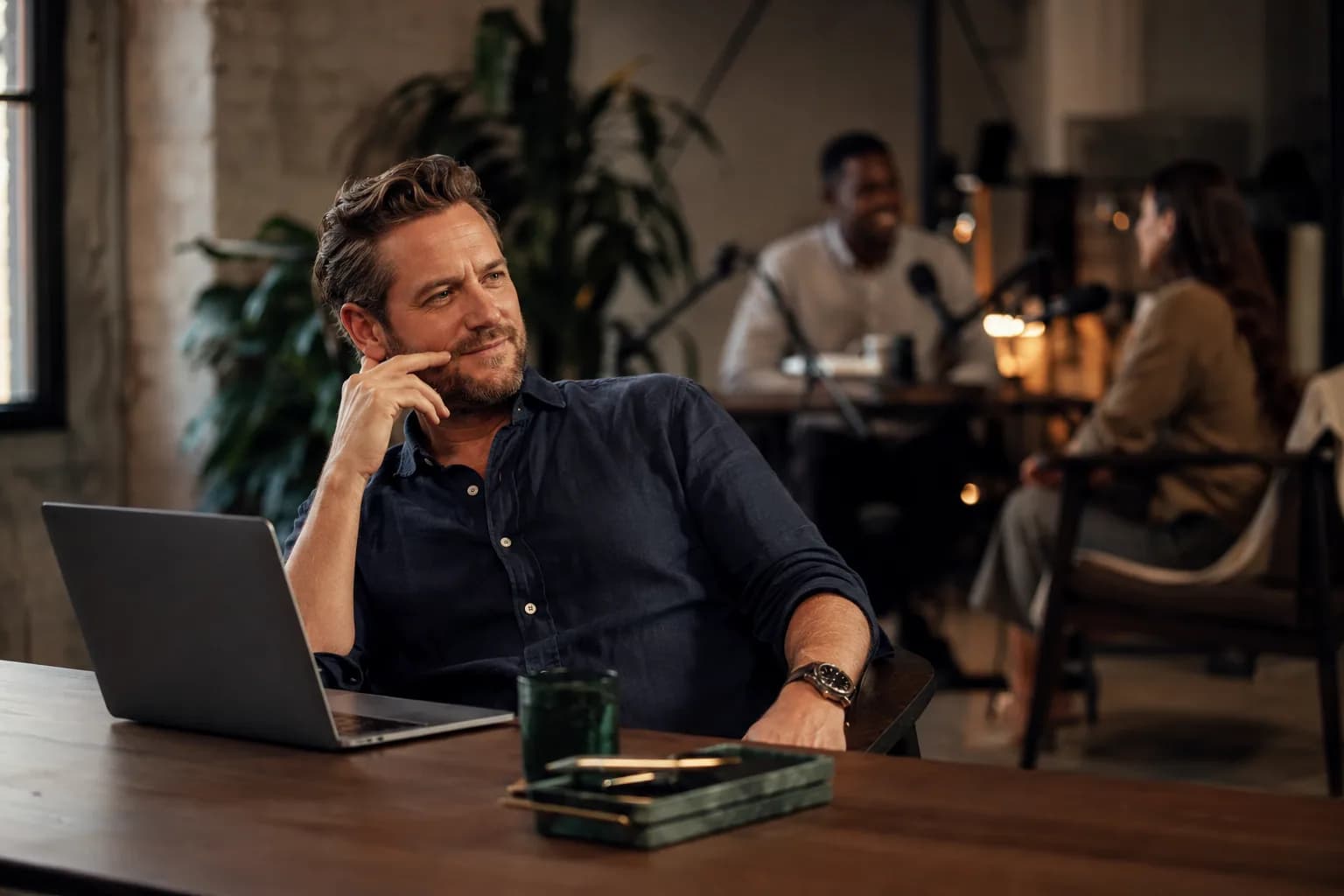 A podcast booker thoughtfully weighing a potential guest in a bright modern studio office, showing the fast credibility judgment that strong authority assets are built to win.