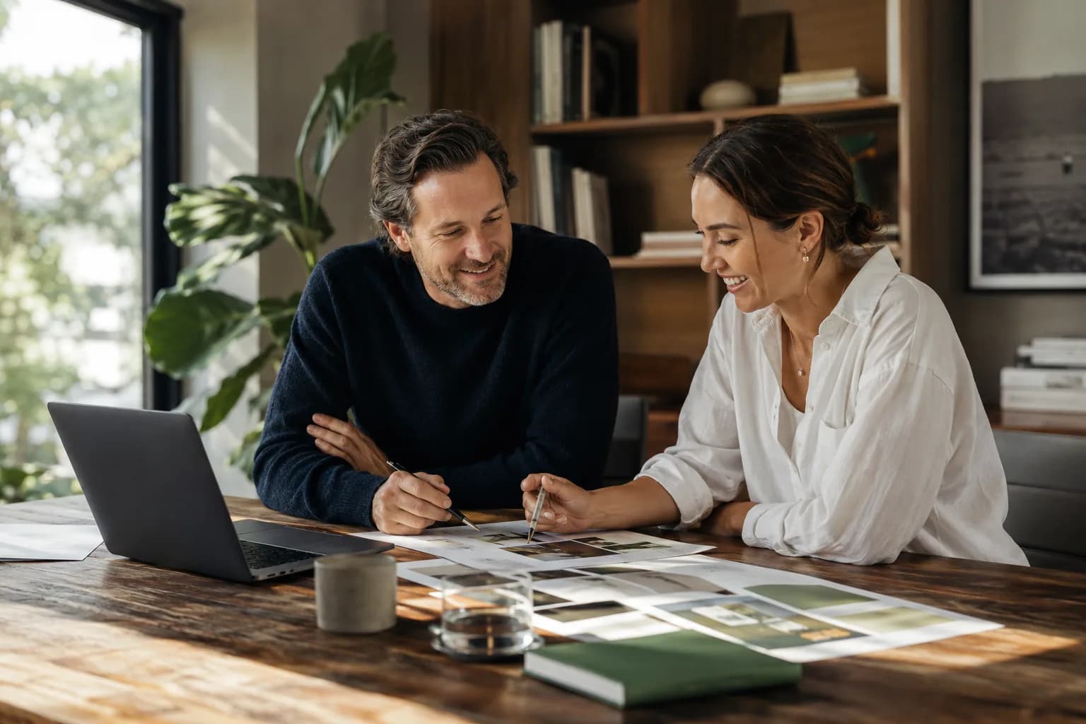 A founder and brand strategist collaborating at a sunlit desk during the foundation phase of a visibility shift, the quiet work that makes the shift look sudden.