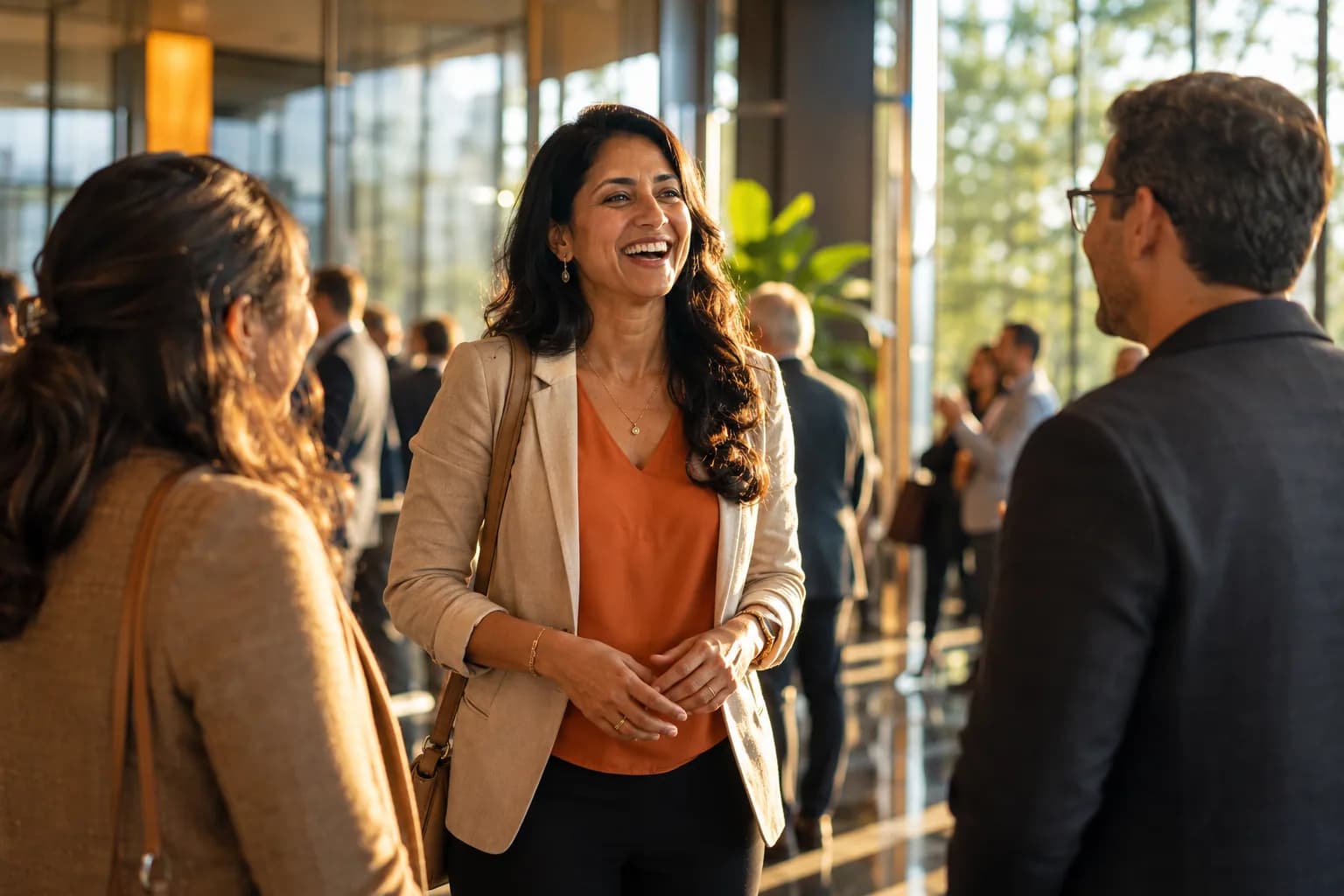 A charismatic founder warmly greeted as the obvious choice in a bright modern event lobby, the result of a 90-day founder visibility shift from best-kept secret to undeniable.