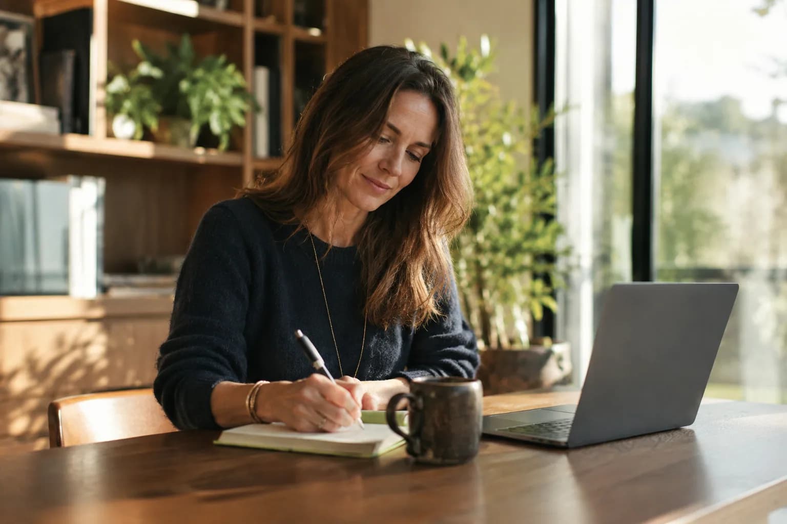 A founder writing by hand at a sunlit desk, showing substance and a real point of view rather than performance for an audience.