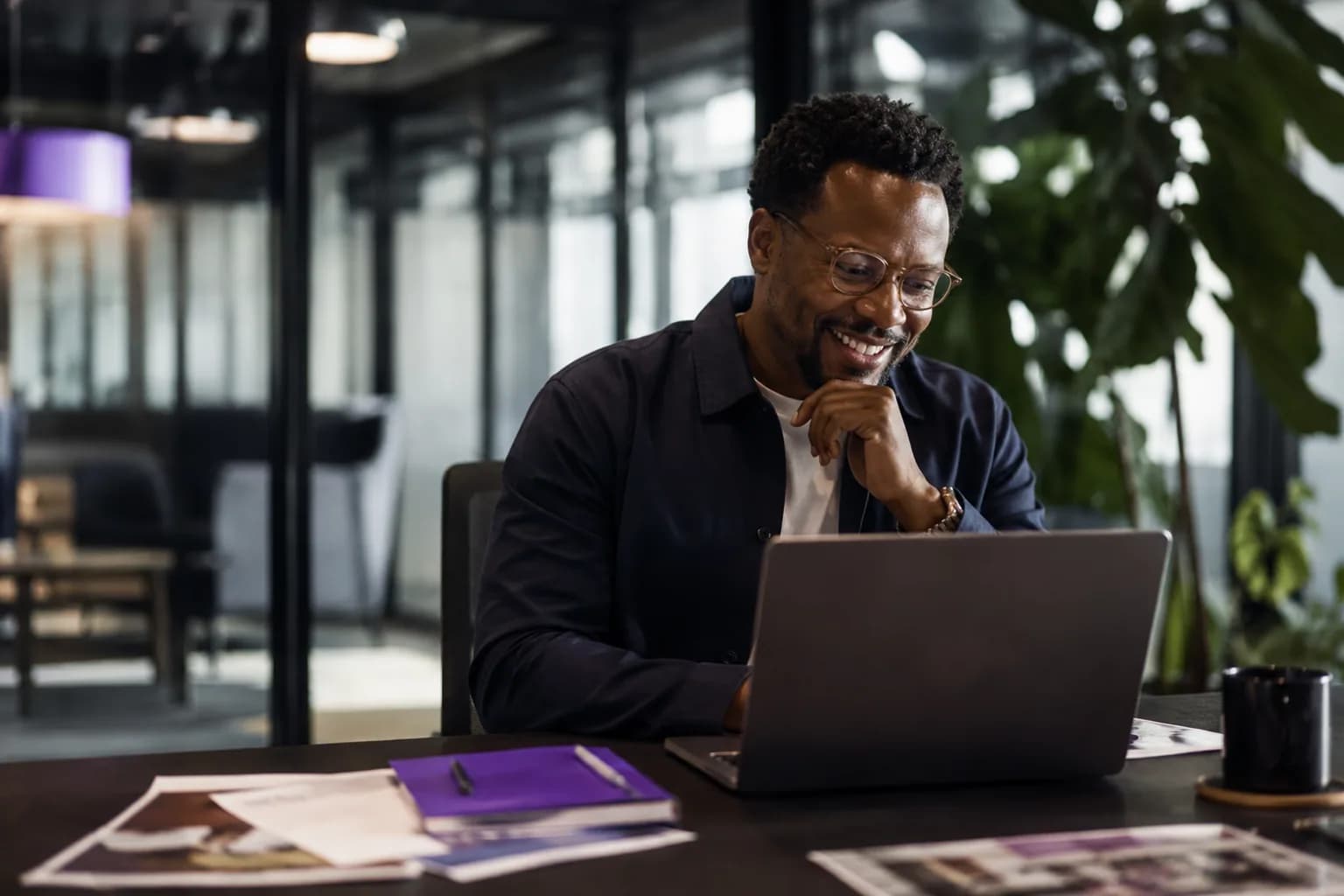 An event organizer deliberating over speaker options in a bright modern office, showing how booking decisions are made on a speaker's brand before the talk is ever seen.