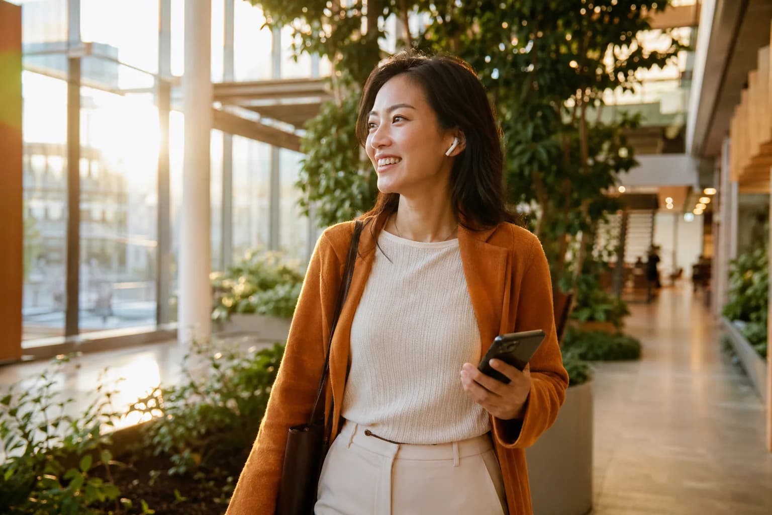 A professional listening attentively through earbuds in a bright sunlit atrium, showing the trusting podcast audience a founder steps into when they borrow rather than build.