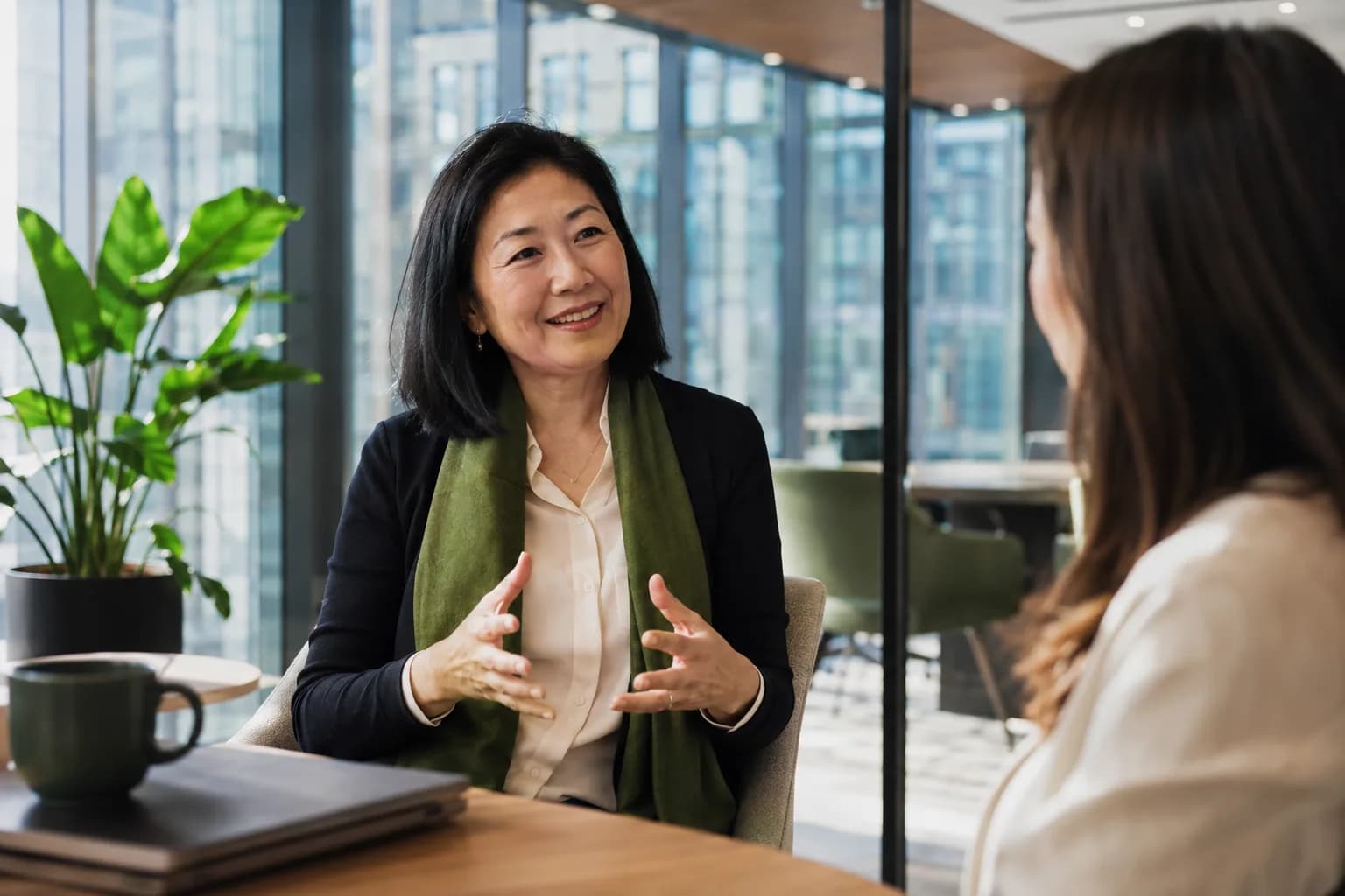A credible founder in confident conversation with a colleague in a bright modern office, illustrating how founder credibility, not content volume, makes a founder the obvious choice.