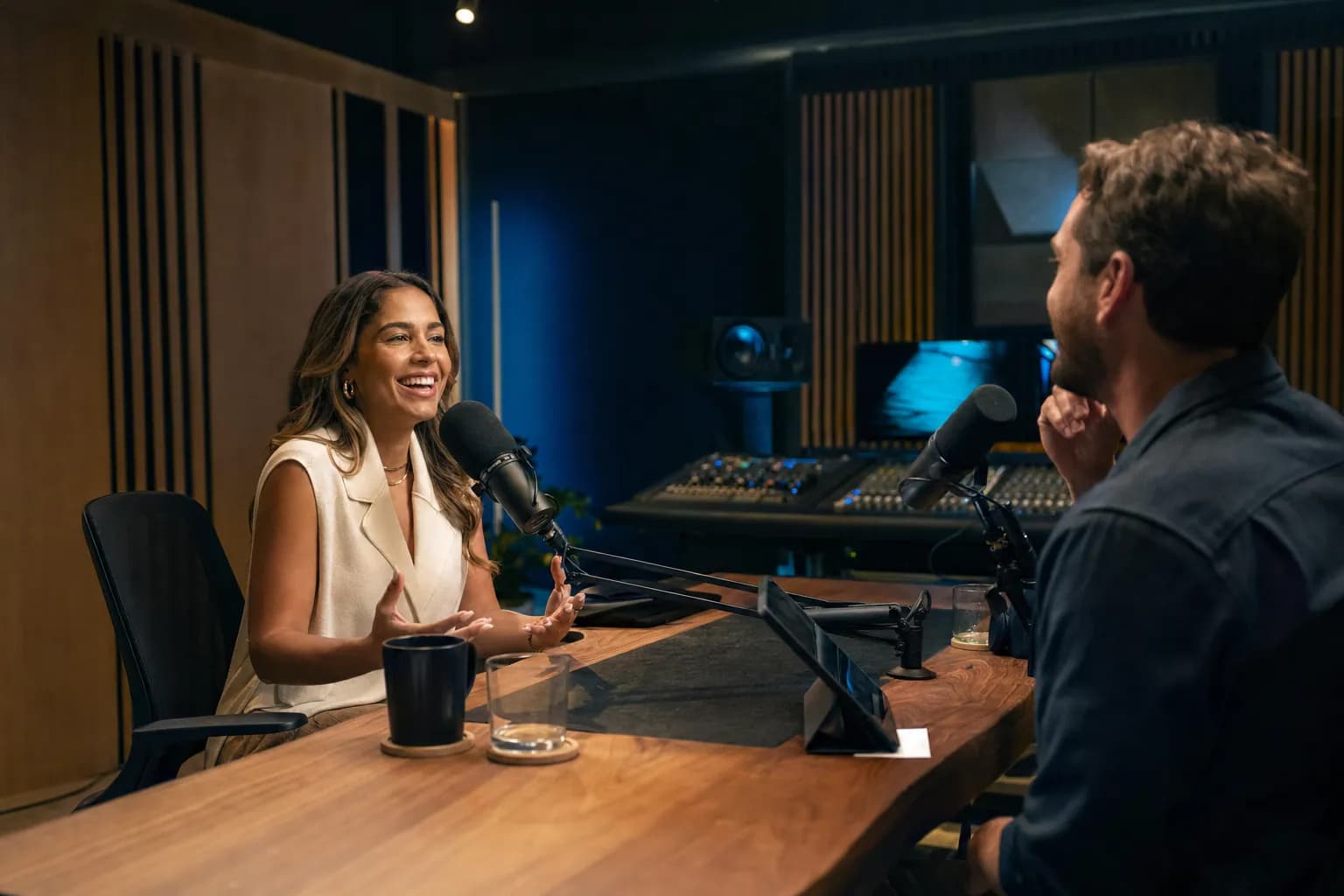 A podcast booking agency client recording an animated conversation in a premium podcast control room, showing how the right show reaches the buyers who move a founder's pipeline.