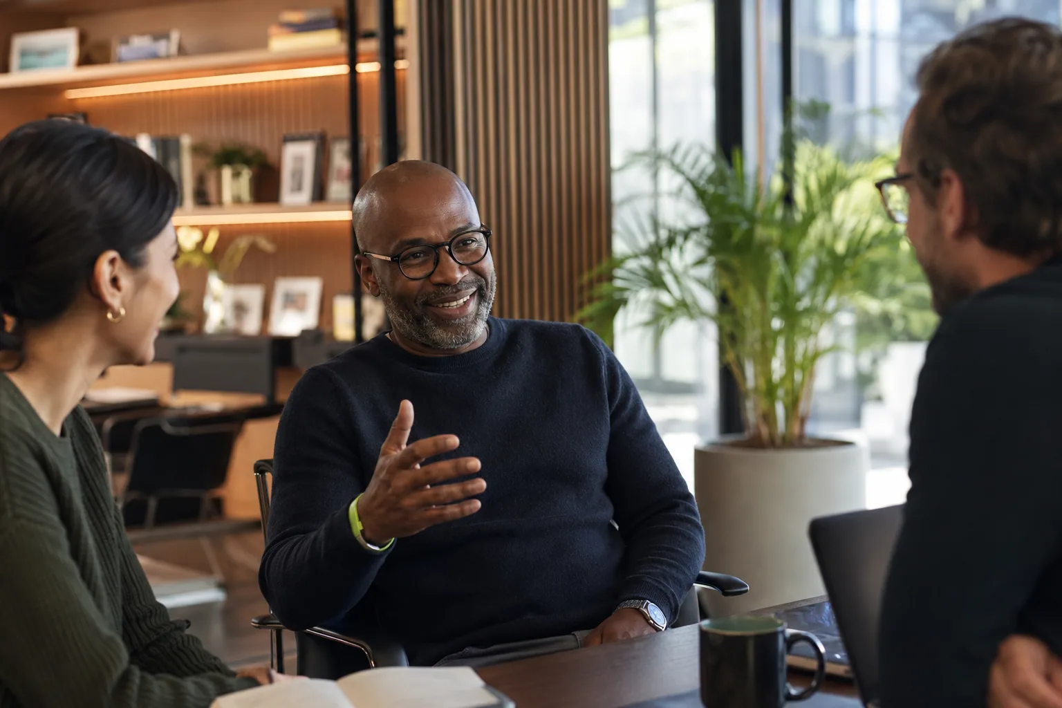 A grounded founder in genuine conversation with his team in a real working office, illustrating the operator credibility that sets a founder apart from an influencer.